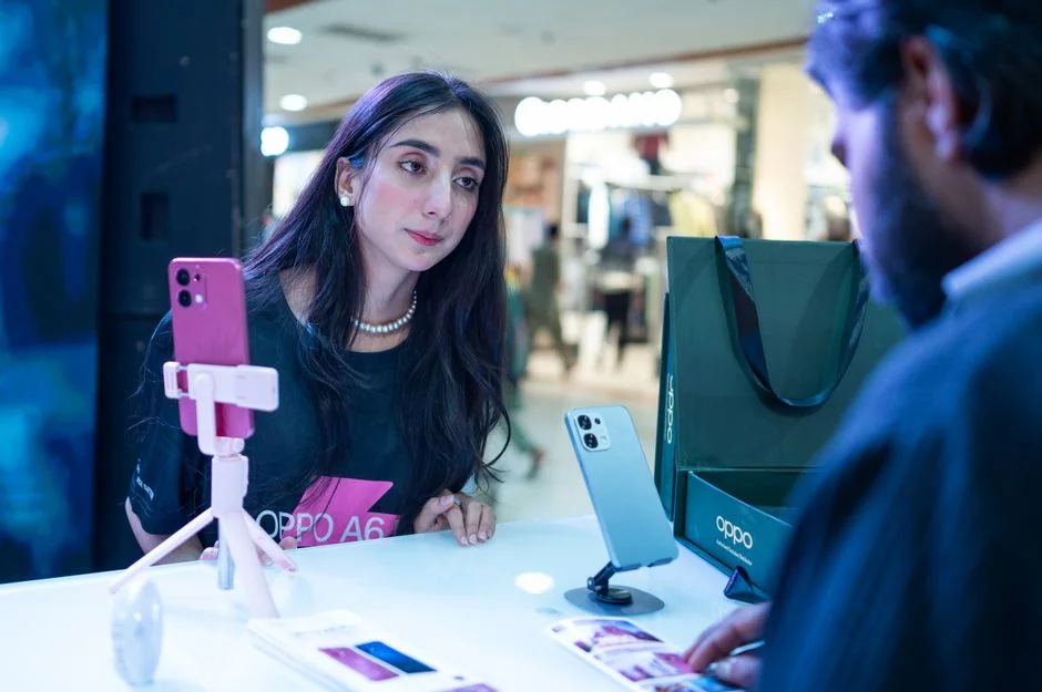 Une personne examine des données boursières à l’aide d’un smartphone et d’un ordinateur portable, en intérieur.